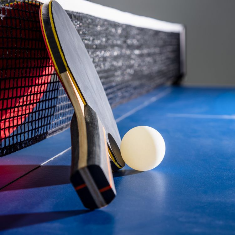 closeup-black-red-table-tennis-racket-white-ball-blue-ping-pong-table-
